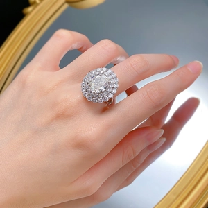 Macro shot of oval-cut high carbon diamond ring with double halo pavé setting