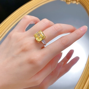 Detailed view of yellow radiant cut diamond ring with tapered baguette side stones on finger