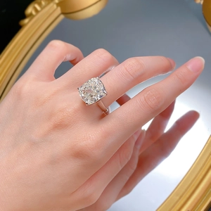 Detail of cushion-cut luxury crystal ring on model hand with elegant mirror reflection