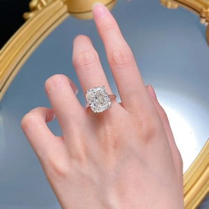 Macro shot of 6 carat cushion cut simulated diamond ring on hand with elegant reflections