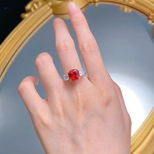 Close-up of pigeon blood red ruby ring with side stones worn on a hand