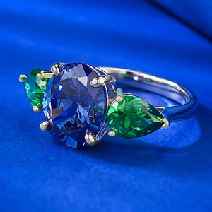 Macro shot of S925 silver ring featuring blue oval stone and green pear side stones