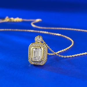 Elegant gold necklace with emerald-cut gem pendant and halo diamonds on blue backdrop