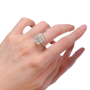Elegant cushion cut 6 carat simulated diamond ring on hand with polished silver band