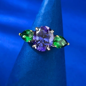 Detailed macro view of S925 silver ring featuring purple oval and green pear-cut stones