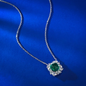Elegant silver necklace featuring a square green gemstone pendant with diamond halo