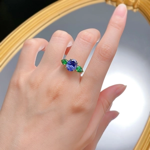 S925 silver ring featuring oval blue tanzanite and pear-shaped green side stones on a finger