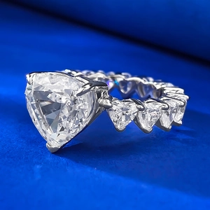 Vue latérale d'une bague avec pierre triangle et diamants latéraux en forme de cœur