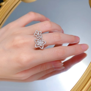 Macro detail of S925 silver hollow floral ring with zircon petals on model's hand