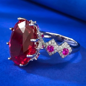 Vue macro d'une bague de luxe avec pierre rouge sang de pigeon et serti de diamants argent