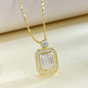 Macro shot of 925 silver perfume bottle pendant with emerald cut stone and gold finish