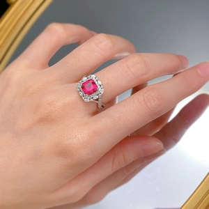 Macro detail of square cut ruby ring featuring intricate double layer halo setting