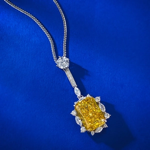 Macro shot of rectangular radiant cut yellow gemstone pendant with diamond accents
