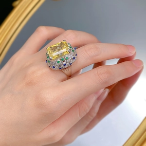 Macro shot of a 15ct radiant cut yellow gemstone ring with multi-color halo accents