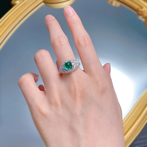 Macro shot of 925 silver ring with 6.5mm sugarloaf emerald and micro-pave halo details