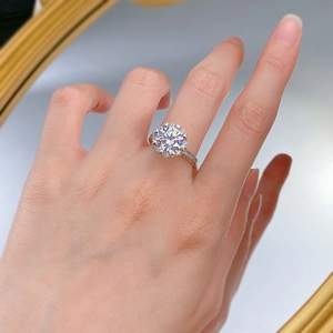Close-up of 3-carat round halo moissanite ring with pave diamonds on hand