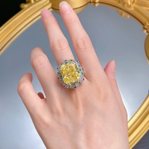Macro detail of 15ct radiant cut yellow diamond ring with sapphire accents on model's hand