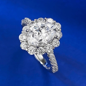 Macro detail of oval cut faux diamond ring with floral halo and pavé band on blue background