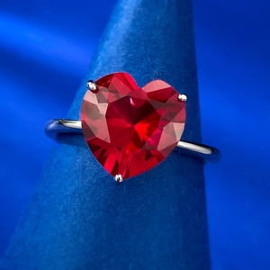 Eleganter S925 Silberring mit 4 Karat herzförmigem rotem Edelstein auf blauem Ständer