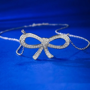 Macro view of 925 sterling silver bow pendant necklace with shimmering pave diamonds