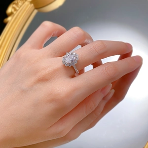Close-up of an oval halo faux diamond ring on a hand with an elegant vintage background