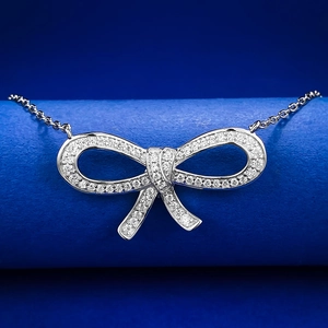 Macro shot of 925 sterling silver bow pendant with detailed pavé diamond setting