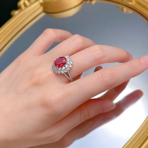 Close-up of S925 silver ring featuring an oval red gemstone and floral cluster diamonds