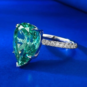 Macro d'une bague en argent S925 avec une pierre vert émeraude taille poire et pavage de diamants