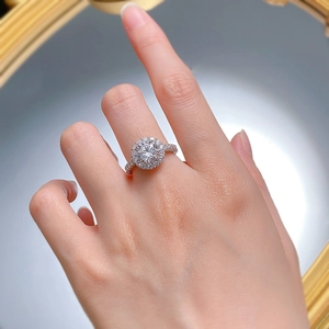 Close-up of a luxury halo diamond ring with round brilliant center stone on a hand