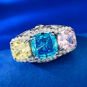 Macro detail of three-stone cushion cut ring with yellow blue and pink gems