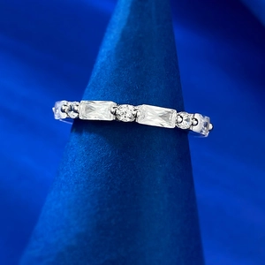 Detailed view of baguette and round cut stones on silver-toned claw set eternity ring
