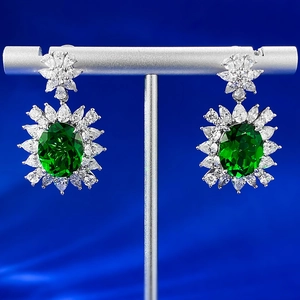 Macro detail of S925 sterling silver earrings with green oval emerald-style stones