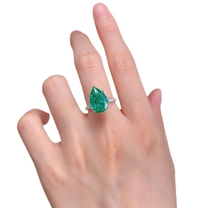 Bague de luxe avec émeraude taille poire et diamants pavés sur anneau en argent poli