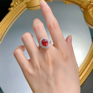 Detail of ruby style oval ring with double diamond halo shown on a vintage mirror