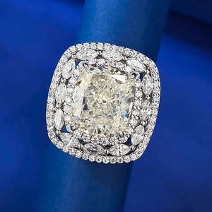 Macro shot of 5 carat yellow cushion cut faux diamond ring with double halo on silver band