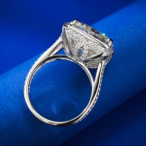 Macro detail of oval cut halo ring with pave diamonds on a navy velvet stand