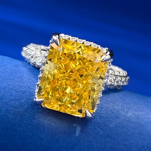 Macro view of a luxury radiant cut yellow diamond ring with a halo and pave setting