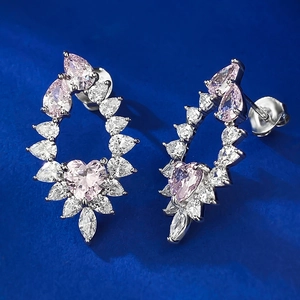 Macro detail of S925 sterling silver earrings with heart pink stone and drop shape crystals