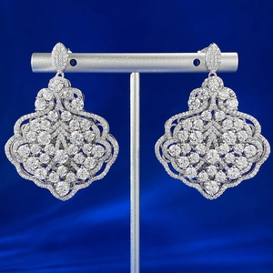 Detailed macro view of silver leaf earrings with full white diamond pavé setting