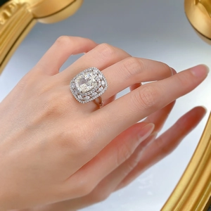 Macro view of cushion-cut 5-carat sparkling diamond double halo silver wedding ring on hand
