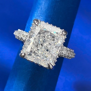 Macro shot of rectangular cut diamond ring with four-prong setting and pavé accents