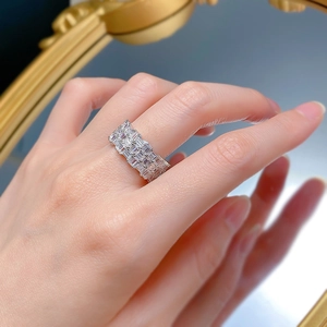 Macro shot of silver-tone wide ring band featuring triple-row baguette-cut zircons