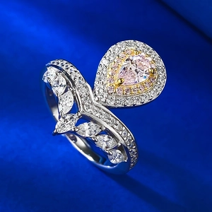 Makroaufnahme eines rosa Diamantrings im Birnenschliff mit seitlichen Marquise-Steinen