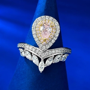 Ring-Set mit birnenförmigem rosa Diamanten und V-förmigem Band auf blauem Kegel