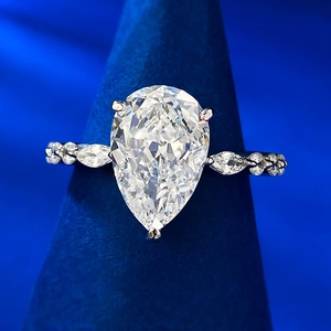 Detailed macro of a pear-shaped carbon diamond ring on a velvet stand display