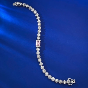Detail of S925 silver tennis bracelet with pink ice cut gem on blue fabric