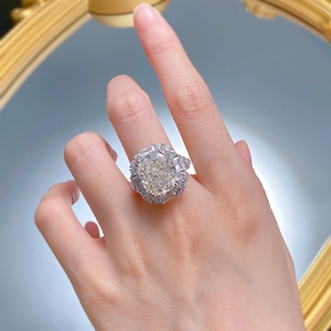Close-up of a luxury cushion-cut yellow stone ring on model hand with silver band