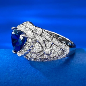 Macro shot of silver ring with heart-cut blue sapphire and pavé cubic zirconia details