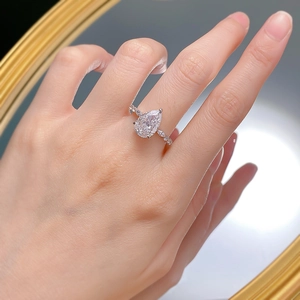 Luxurious S925 silver pear-cut high carbon diamond ring shown in a mirror reflection