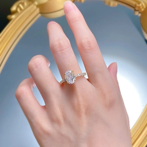 Lussuoso anello in argento S925 con gemma ovale sulla mano di una modella vicino allo specchio